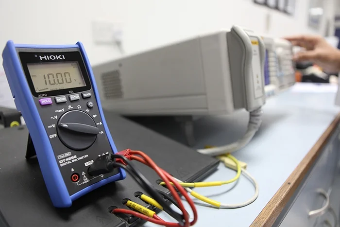 A digital multimeter under test on a calibration bench