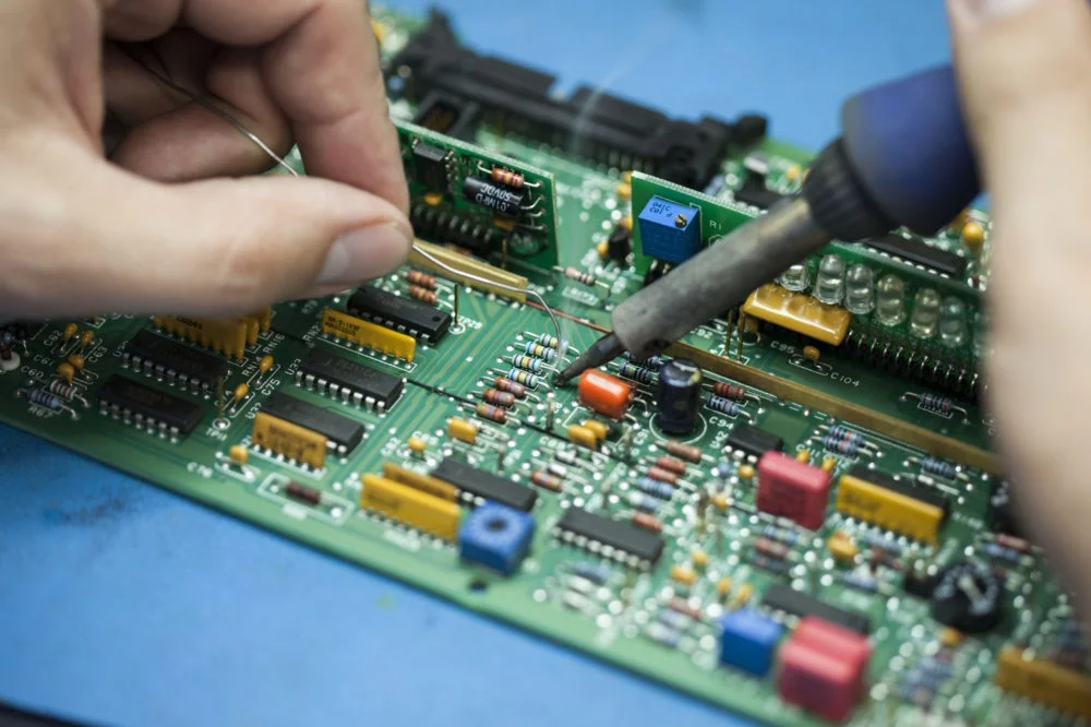 An engineer repairing an instrument circuit board