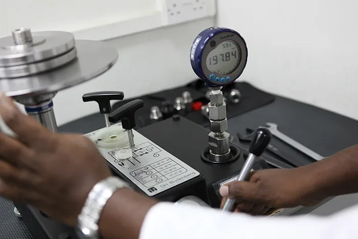 A pressure gauge under test against a reference standard
